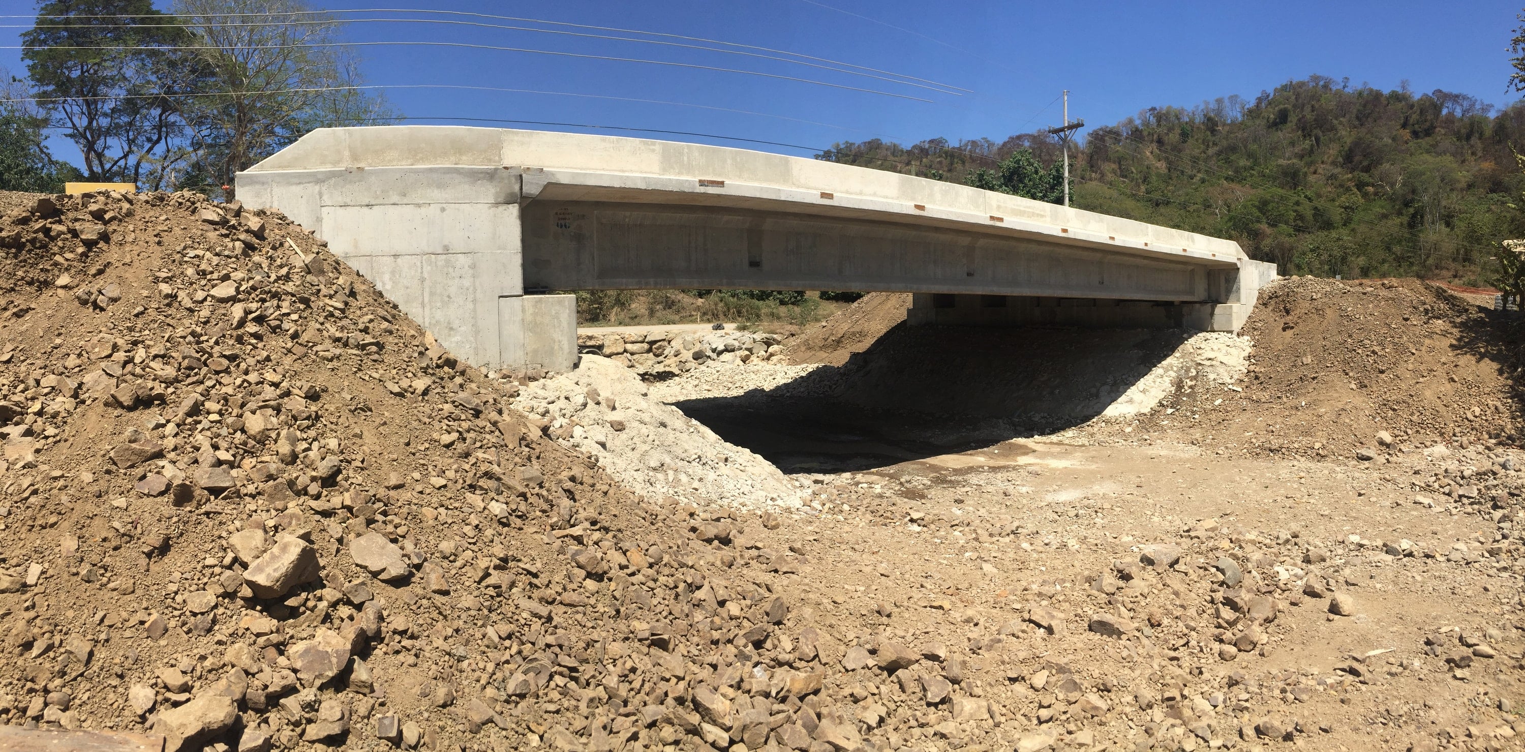 Concrete crossing under construction over an embankment.